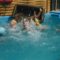 A Few Kids Play Games With Older Adults In A Swimming Pool.