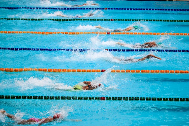 A group of swimmers swimming in a public pool facility.