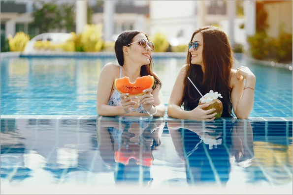 Two Girls Tanning Having Fruit By Pool